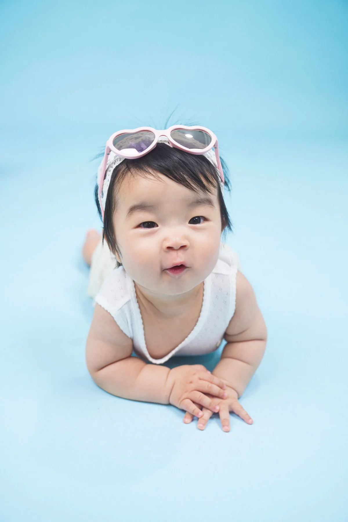 파란 배경에서 분홍 하트 선글라스를 쓴 하름이