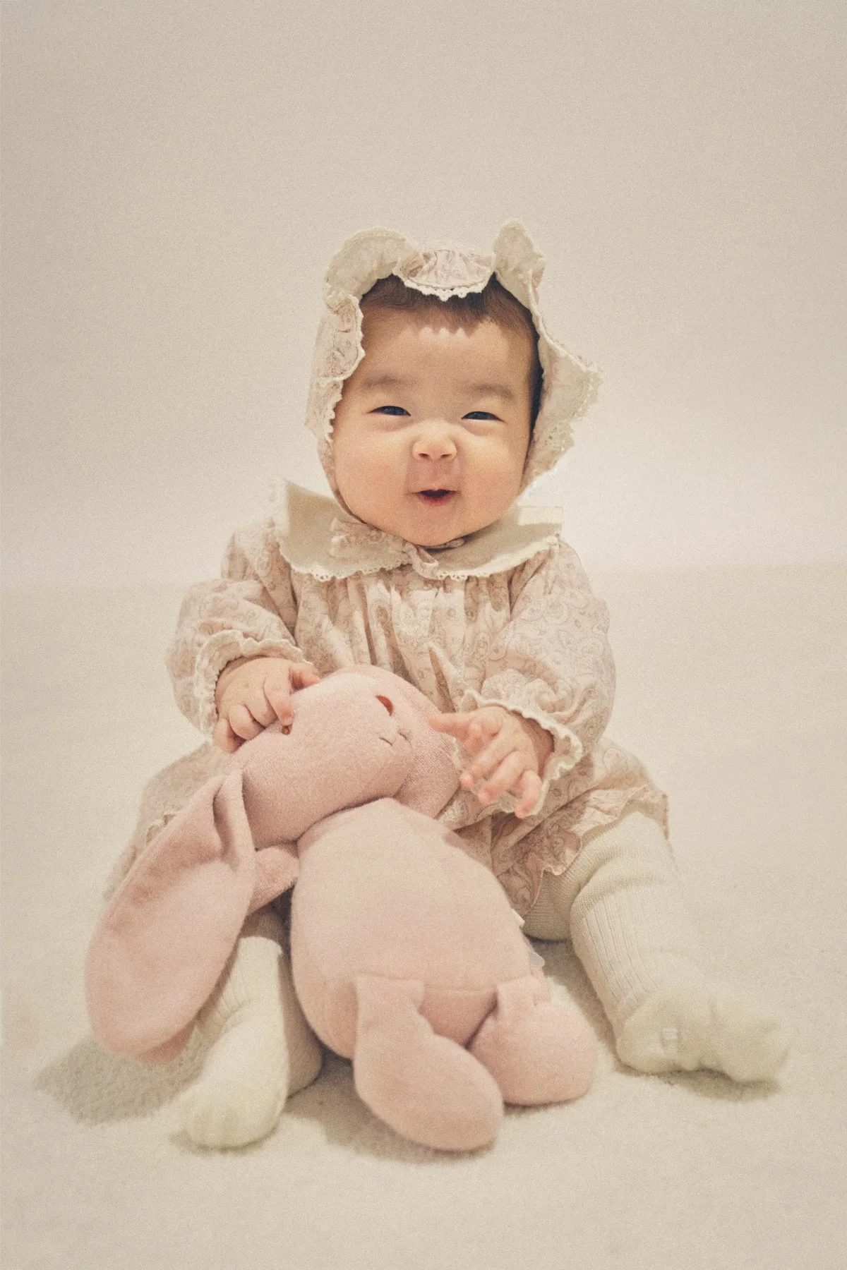 분홍색 옷을 입고 토끼 인형과 함께 웃는 하름이