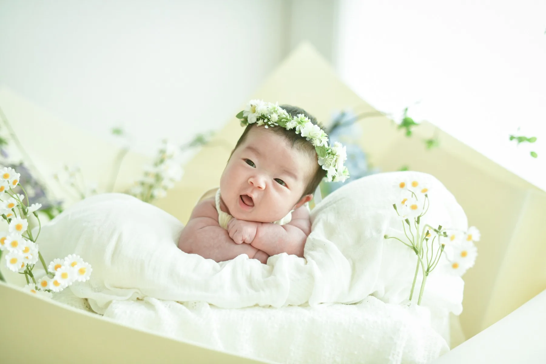 하얀 꽃관을 쓰고 꽃 사이에서 웃는 신생아 하름이